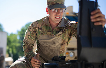 man in military uniform working on equipment