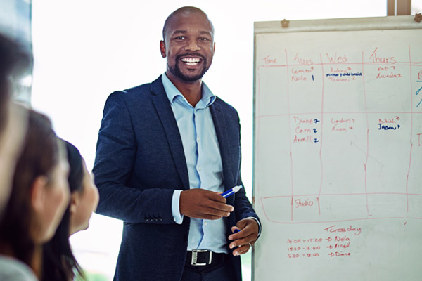 A man stands in front of a whiteboard