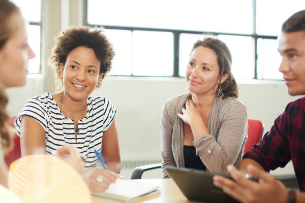 A group of people talk while sitting at a table