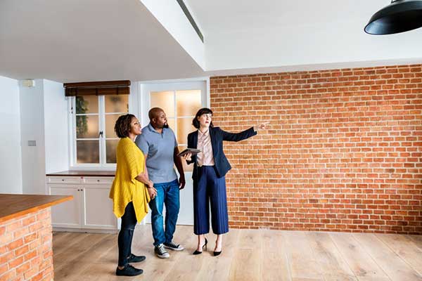 A real estate agent talks to two people