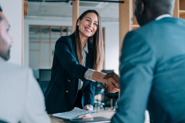 A businesswoman concludes a deal with a handshake.