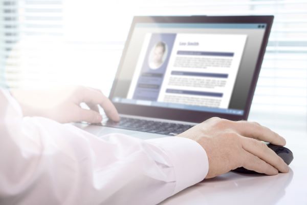 Job seeker writing his resume on a laptop