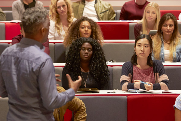 A teacher stands in front of a group of students