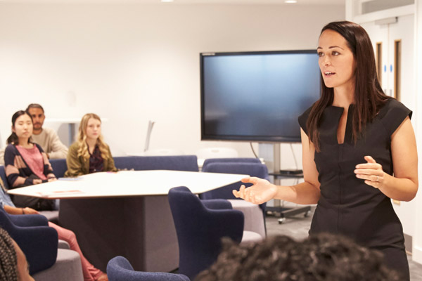 A teacher stands in front of a group of students