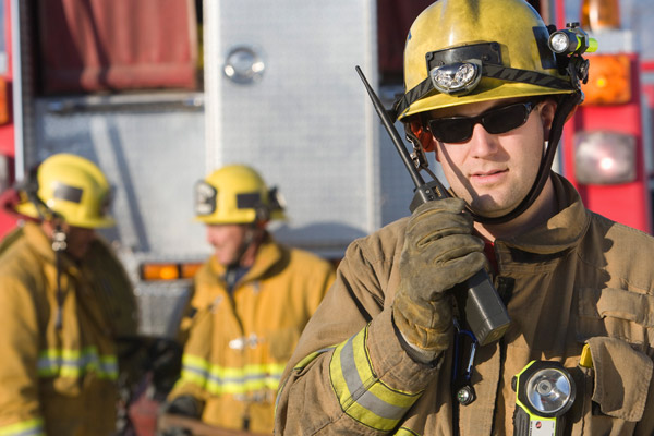 Three firemen stand in their uniforms