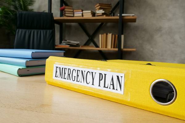 A family’s emergency plan in a yellow binder on a desk.
