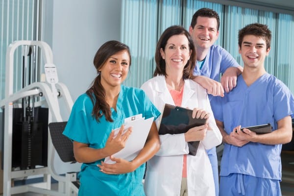 A group of medical assistant students stand together in a hospital