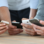 A group of people holding mobile phones