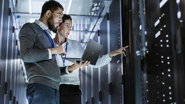 Two people standing in a server room