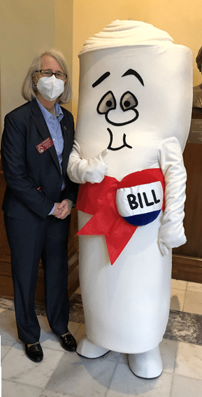 Karla Drenner stands with a person in a costume representing a bill.