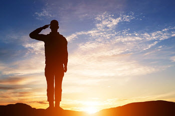 A soldier stands and salutes.