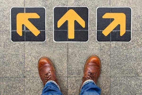 A person stands in front of three arrows