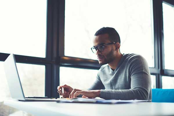 A man sits at a desk in front of a computer