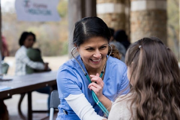 A community health nurse examines a young patient