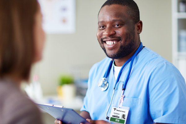 A male nurse smiles at a patient.