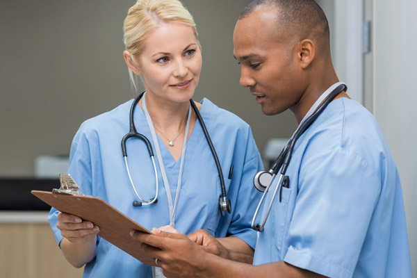Two nurses discuss a patient's chart