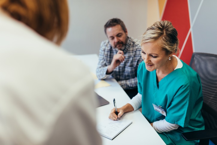 A nurse writes on a piece of paper