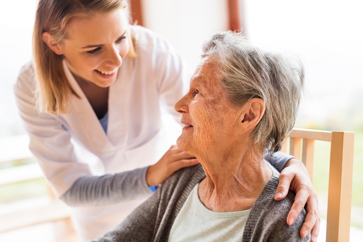 female nurse checking on an elderly female patient