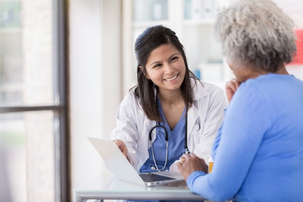 A health care professional talks to a patient