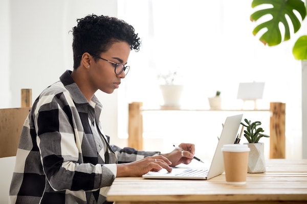 A female student completes a paper by getting APA citations from her computer.