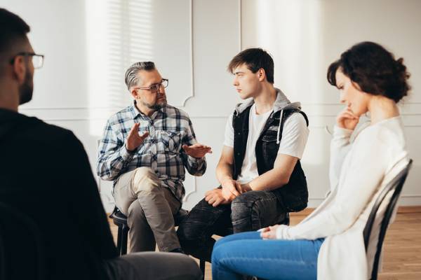 Several people attend a support group focused on substance use disorders