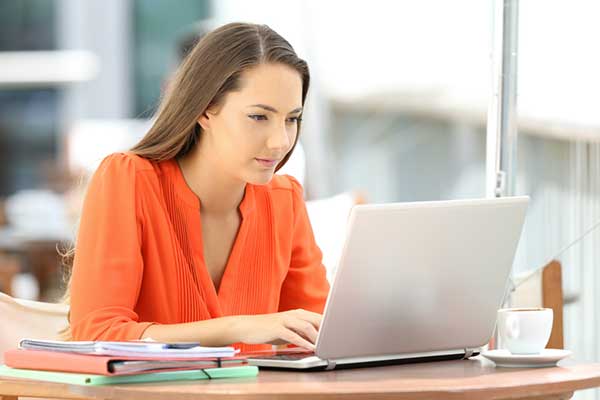 An online student attends class on her laptop.