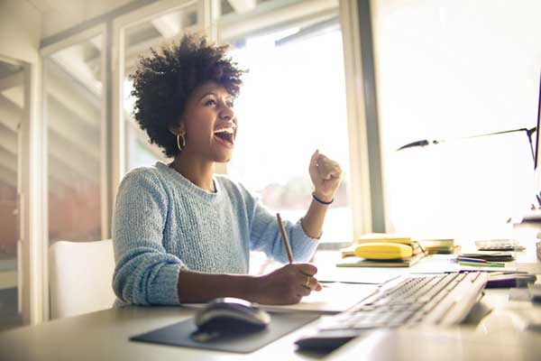 A woman smiles while sitting at a desk