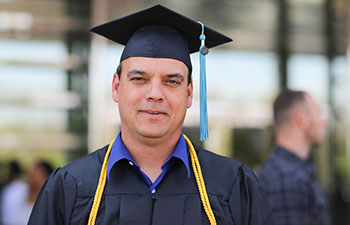 Man Purdue Global Graduate in cap and gown