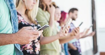 A group of people looking at their mobile devices.