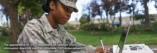 female servicemember working on a laptop